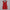 Red mini dress on a hanger against a white curtain background