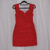 Red mini dress on a hanger against a white curtain background