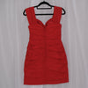 Red mini dress on a hanger against a white curtain background