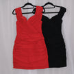 Red mini dress on a hanger against a white curtain background