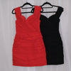 Red mini dress on a hanger against a white curtain background