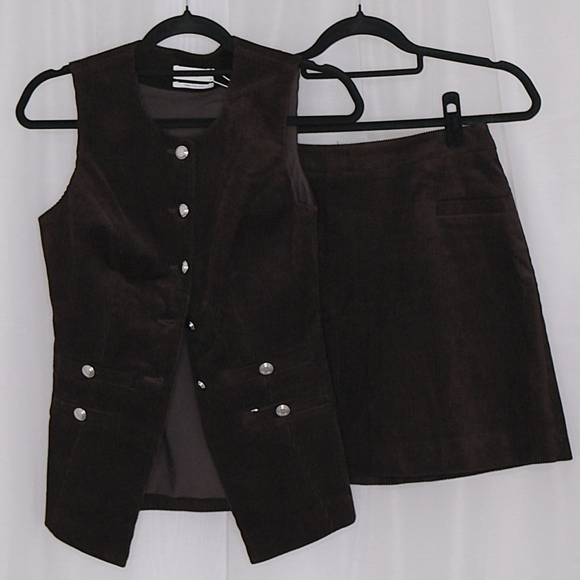 Chocolate corduroy vest and skirt set on hangers against a white background