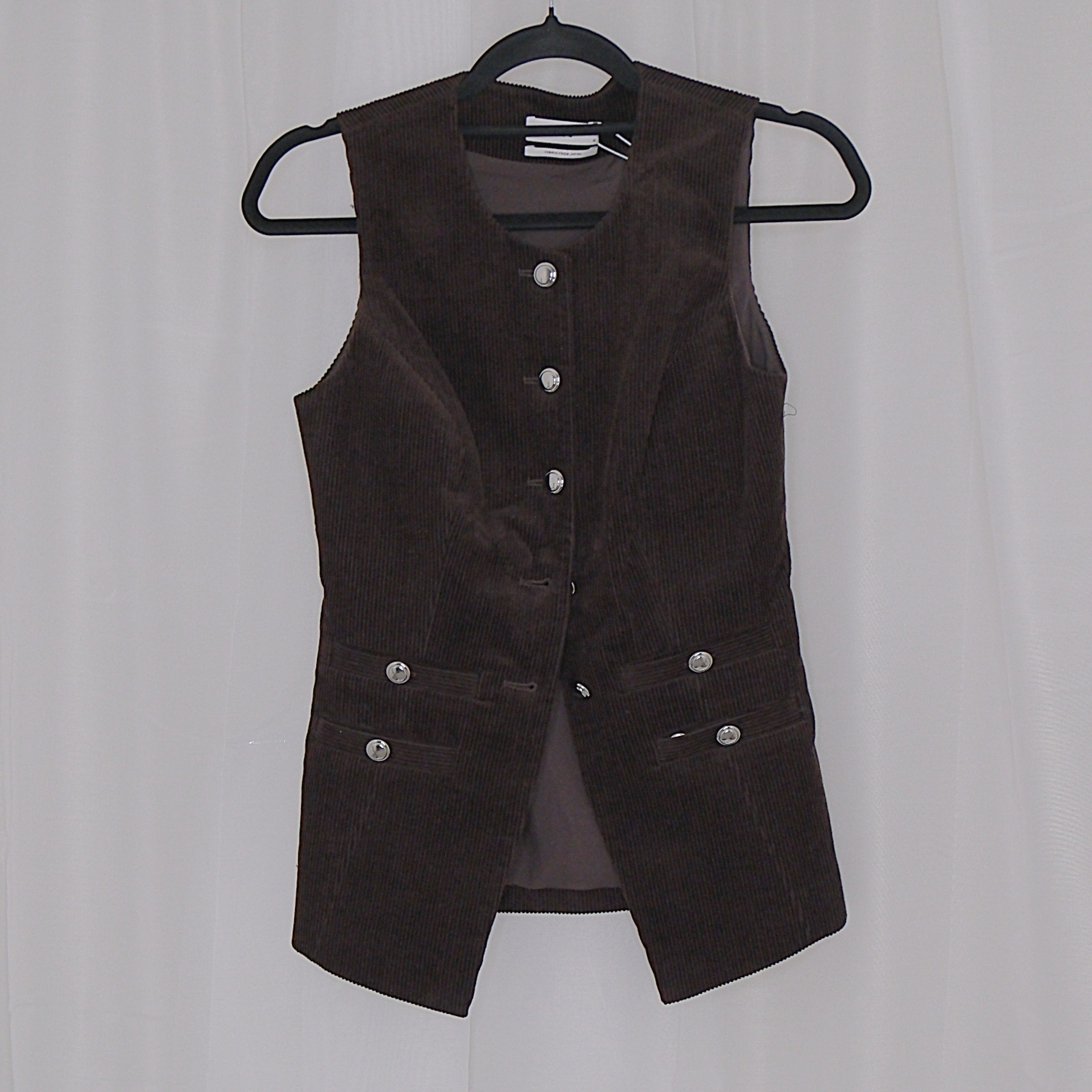 Chocolate corduroy vest and skirt set on hangers against a white background