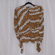 Leopard print top on a hanger against a plain background