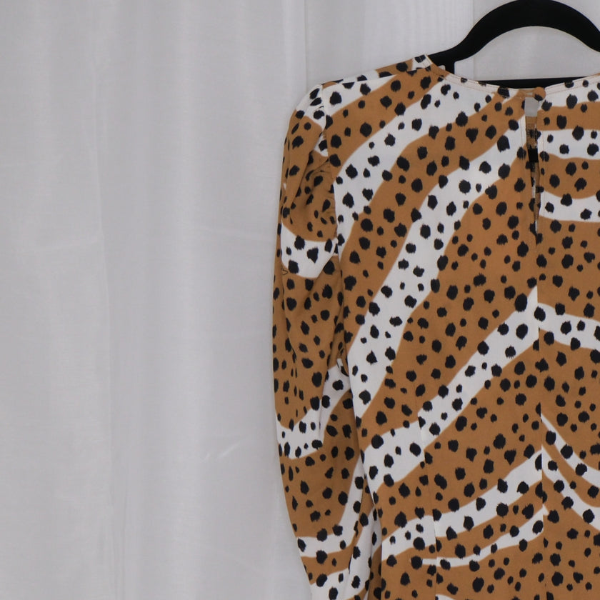 Leopard print top on a hanger against a plain background