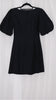 Black mini dress with puff sleeves on a hanger against a white background
