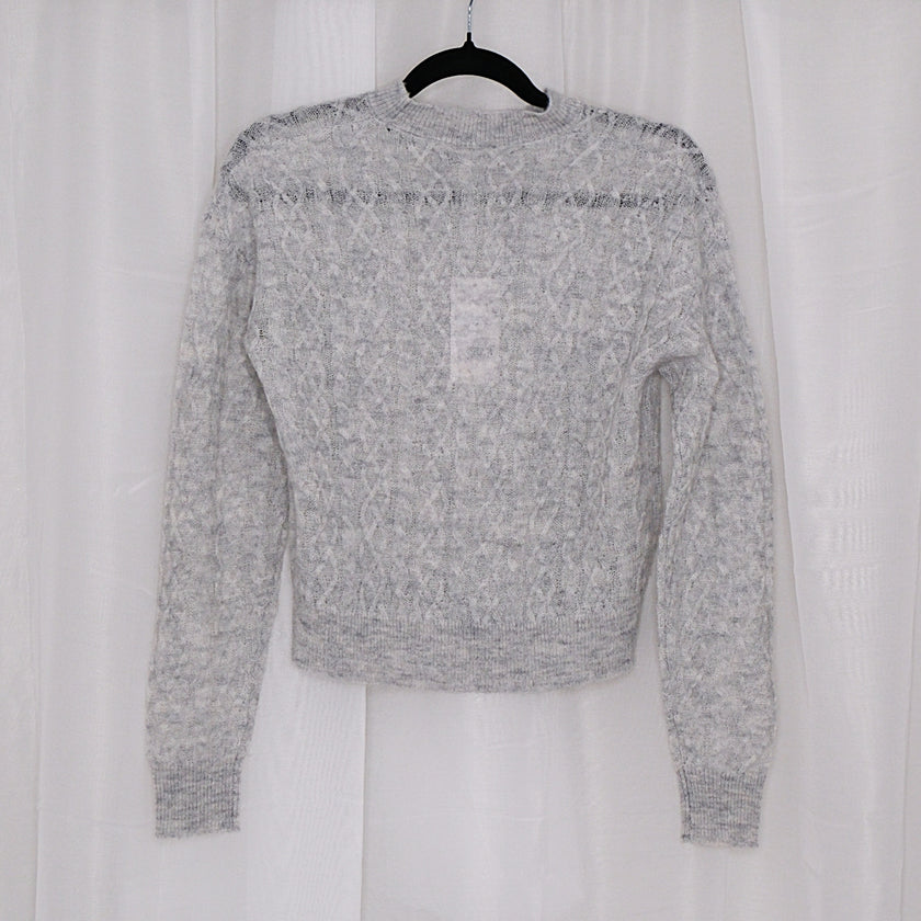Grey sweater on a hanger against a white background