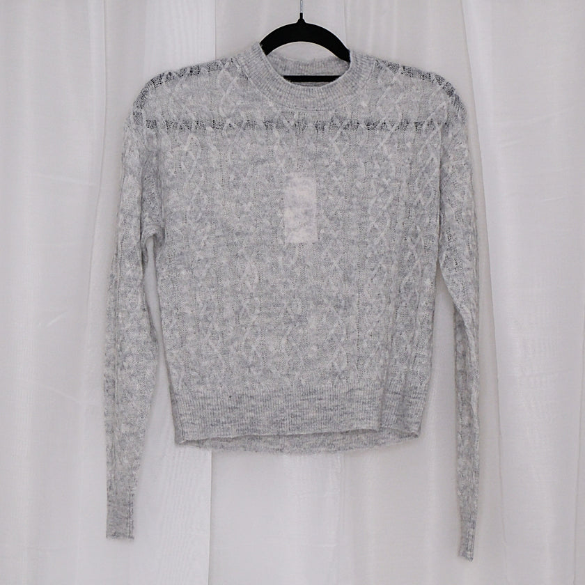 Grey sweater on a hanger against a white background