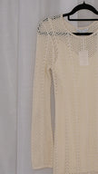 Beige long-sleeve crochet dress on a hanger against a light white background