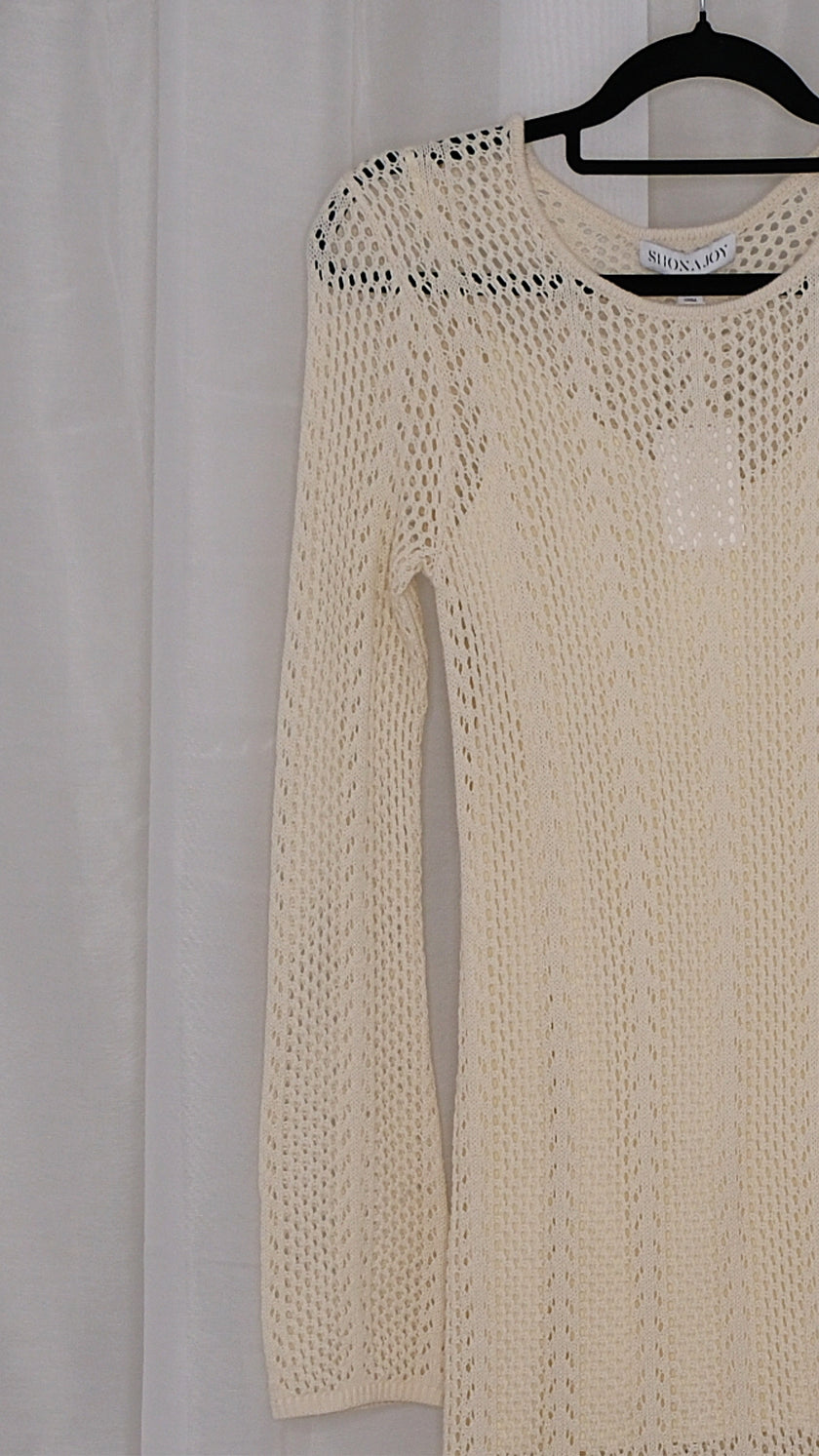 Beige long-sleeve crochet dress on a hanger against a light white background