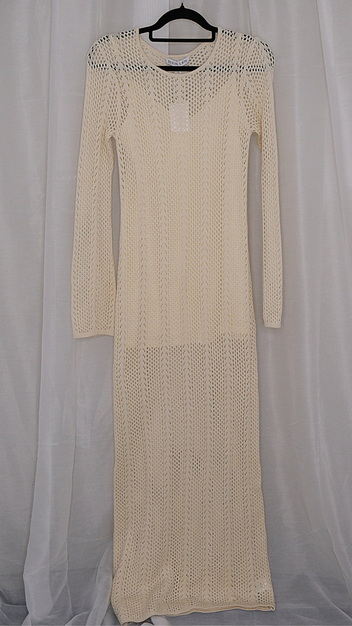 Beige long-sleeve crochet dress on a hanger against a light white background