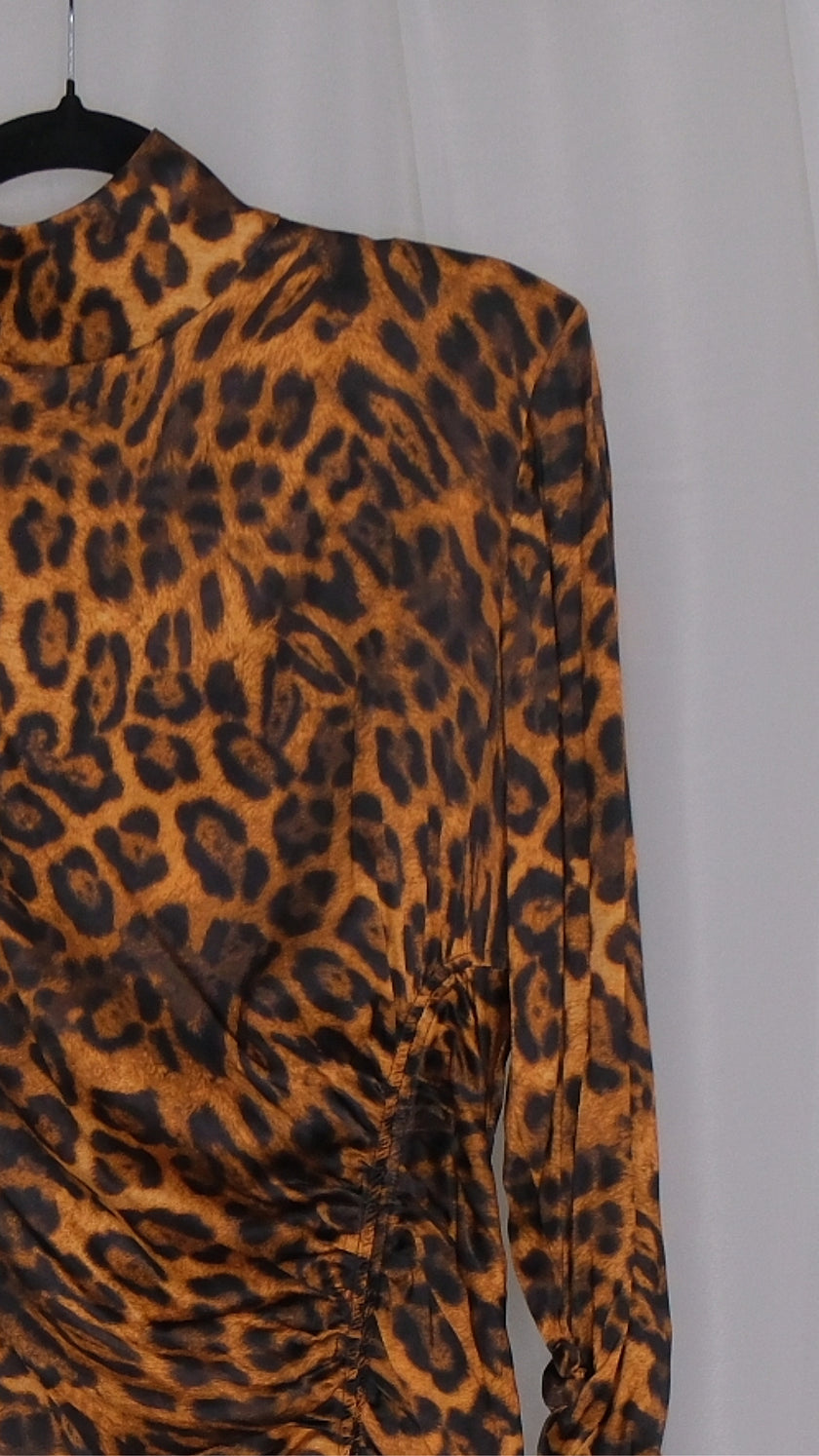 Leopard print dress on a hanger against a plain background