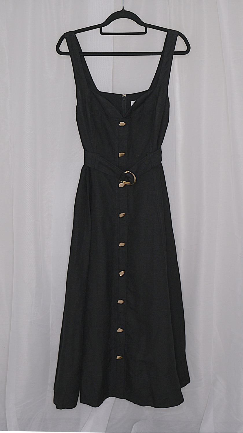 Black dress with gold buttons and belt on a hanger against a light white background