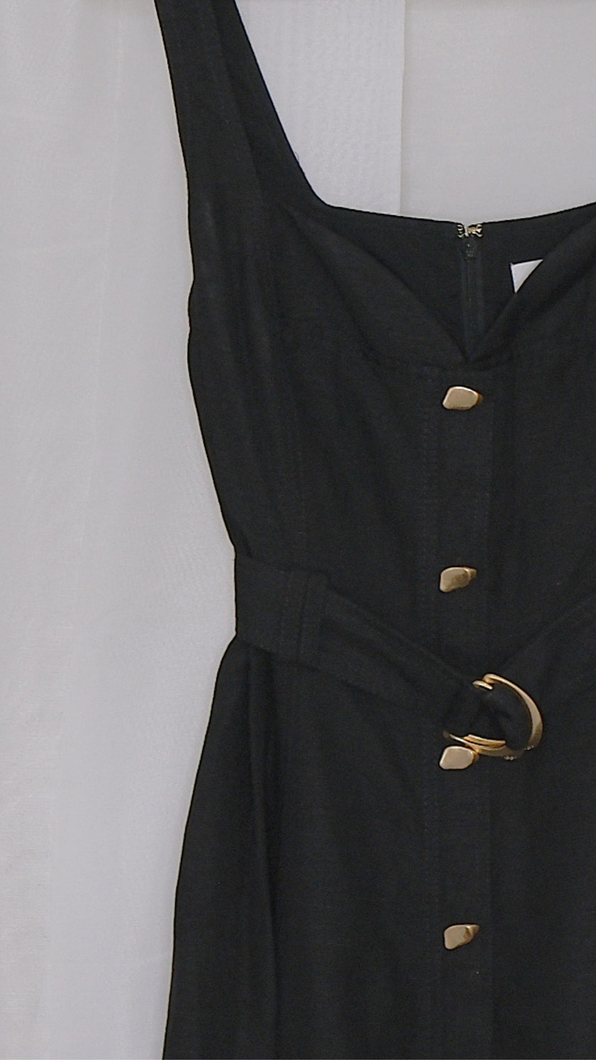 Black dress with gold buttons and belt on a hanger against a light white background