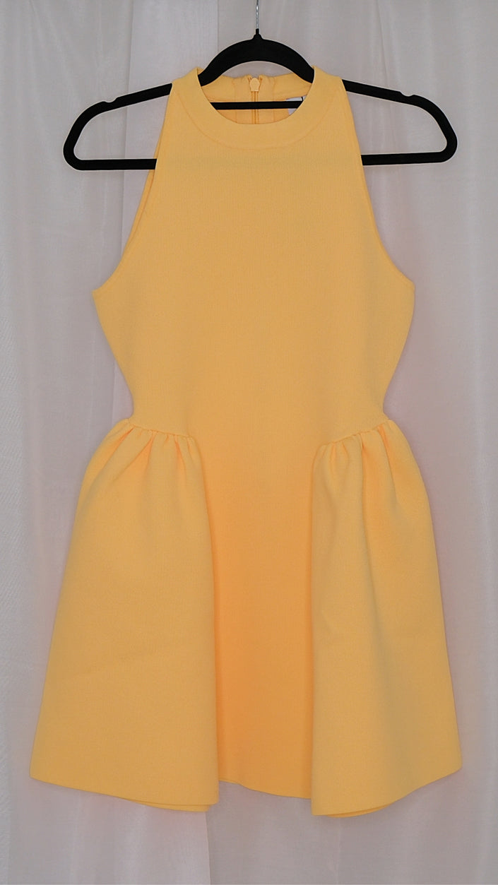 Yellow dress on a hanger against a white background