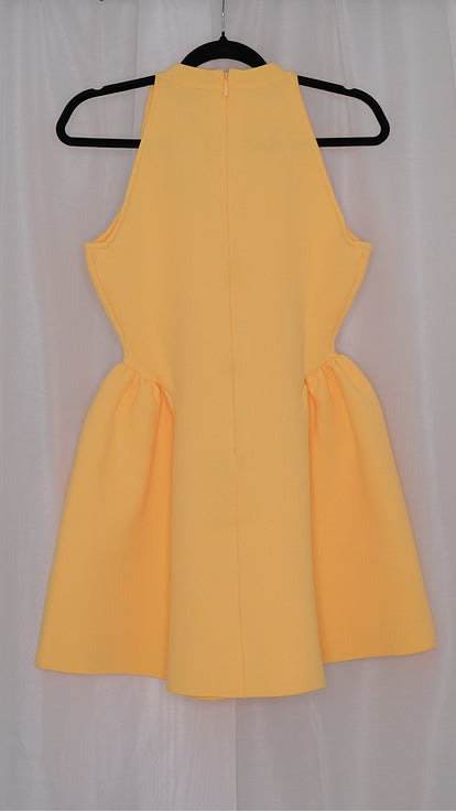 Yellow dress on a hanger against a white background
