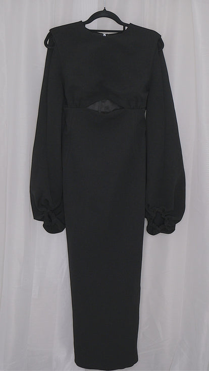 Black dress with long sleeves and cut outs on a hanger against a white background