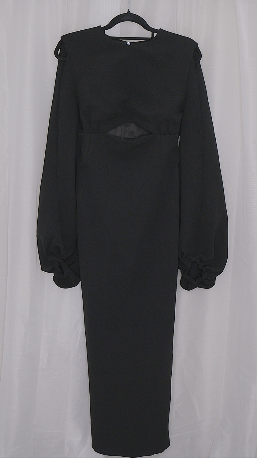 Black dress with long sleeves and cut outs on a hanger against a white background