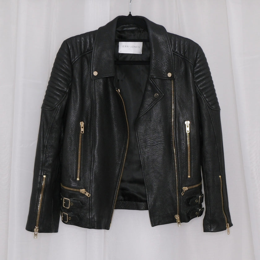 Black leather jacket with gold zippers on a white background