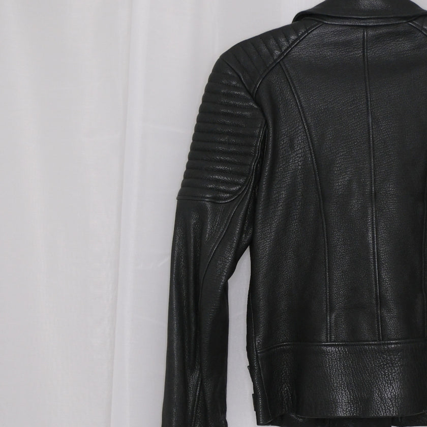 Black leather jacket with gold zippers on a white background