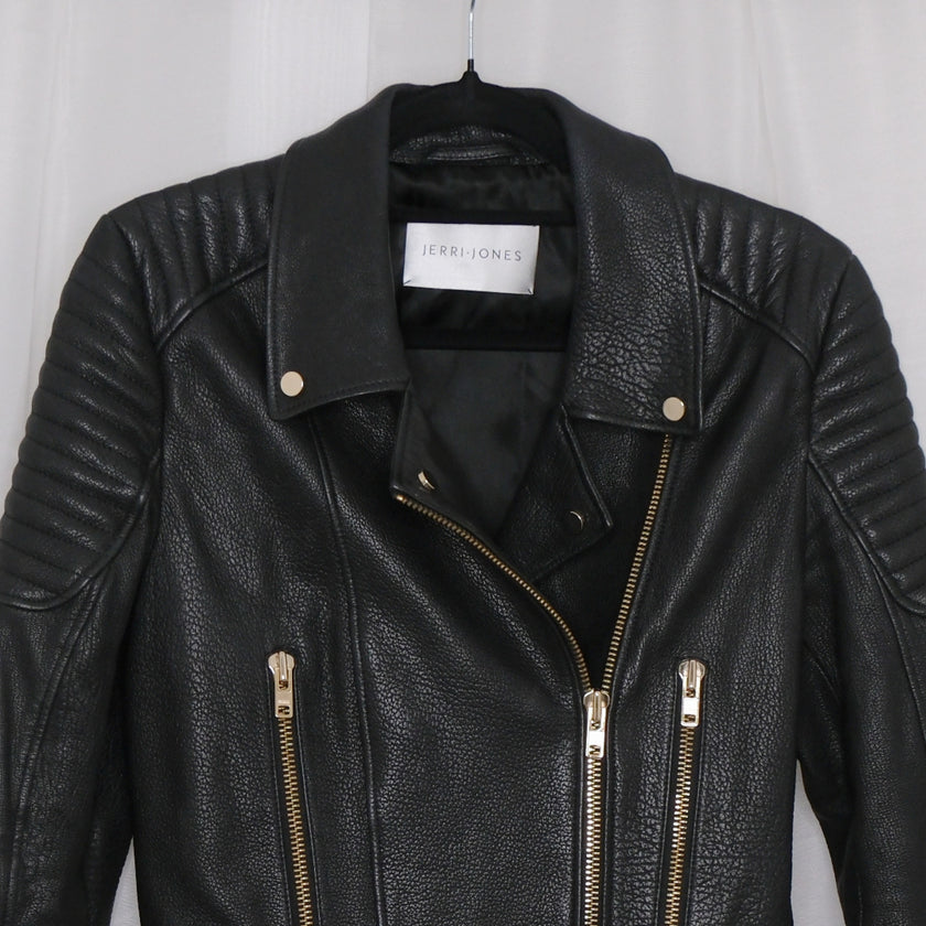 Black leather jacket with gold zippers on a white background