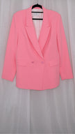 Pink suit with blazer and pants on hangers against a plain background