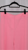 Pink suit with blazer and pants on hangers against a plain background