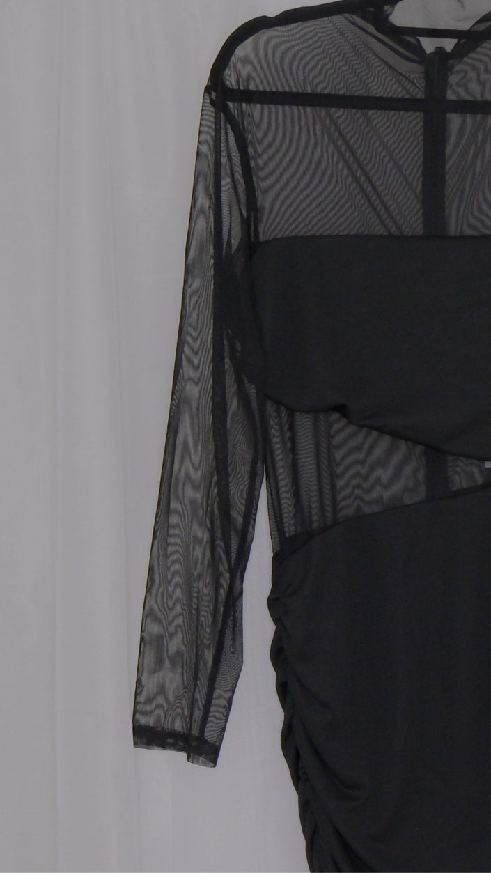 Black mesh dress with sheer sleeves on a hanger against a white background