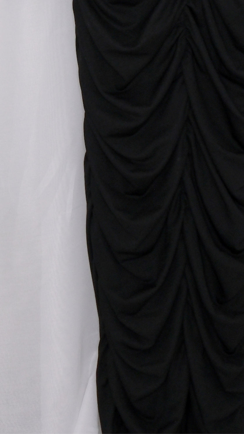 Black mesh dress with sheer sleeves on a hanger against a white background