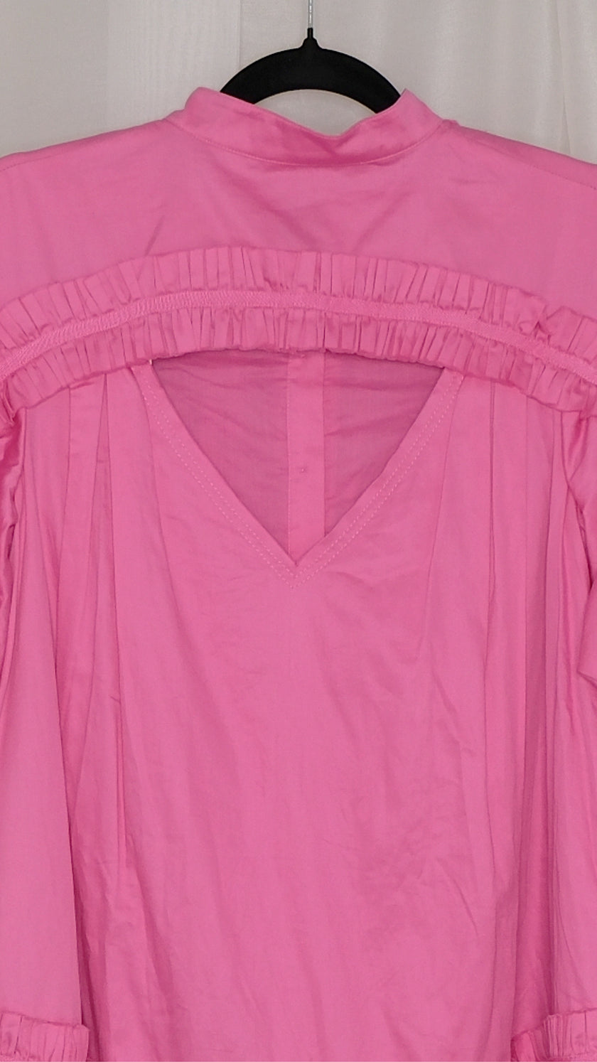Pink dress with ruffled layers on a hanger against a plain background