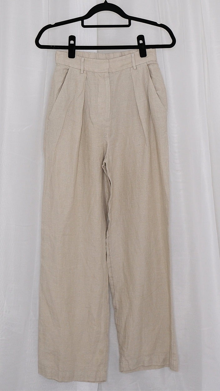 Beige pants on a hanger against a white background