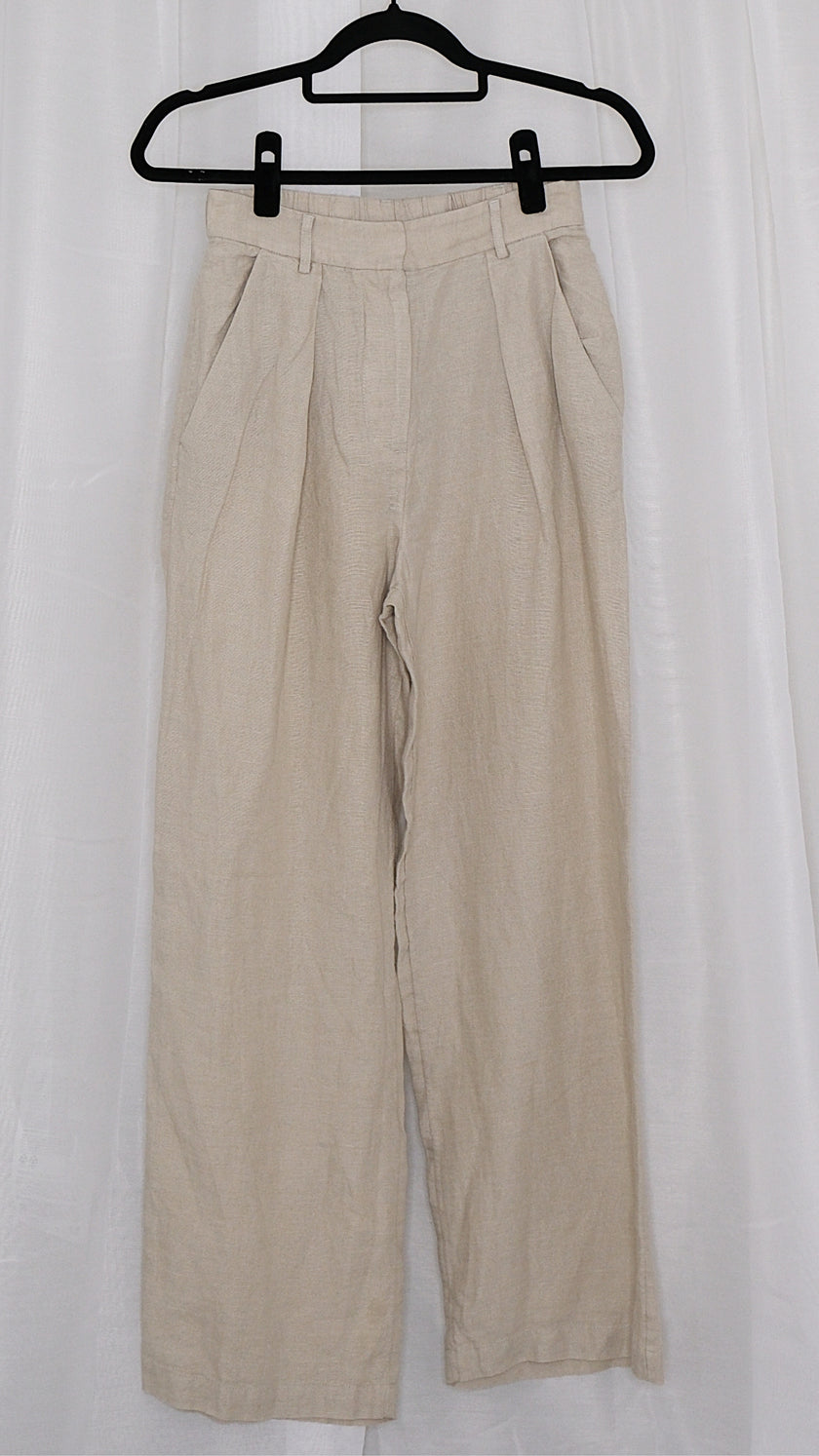 Beige pants on a hanger against a white background