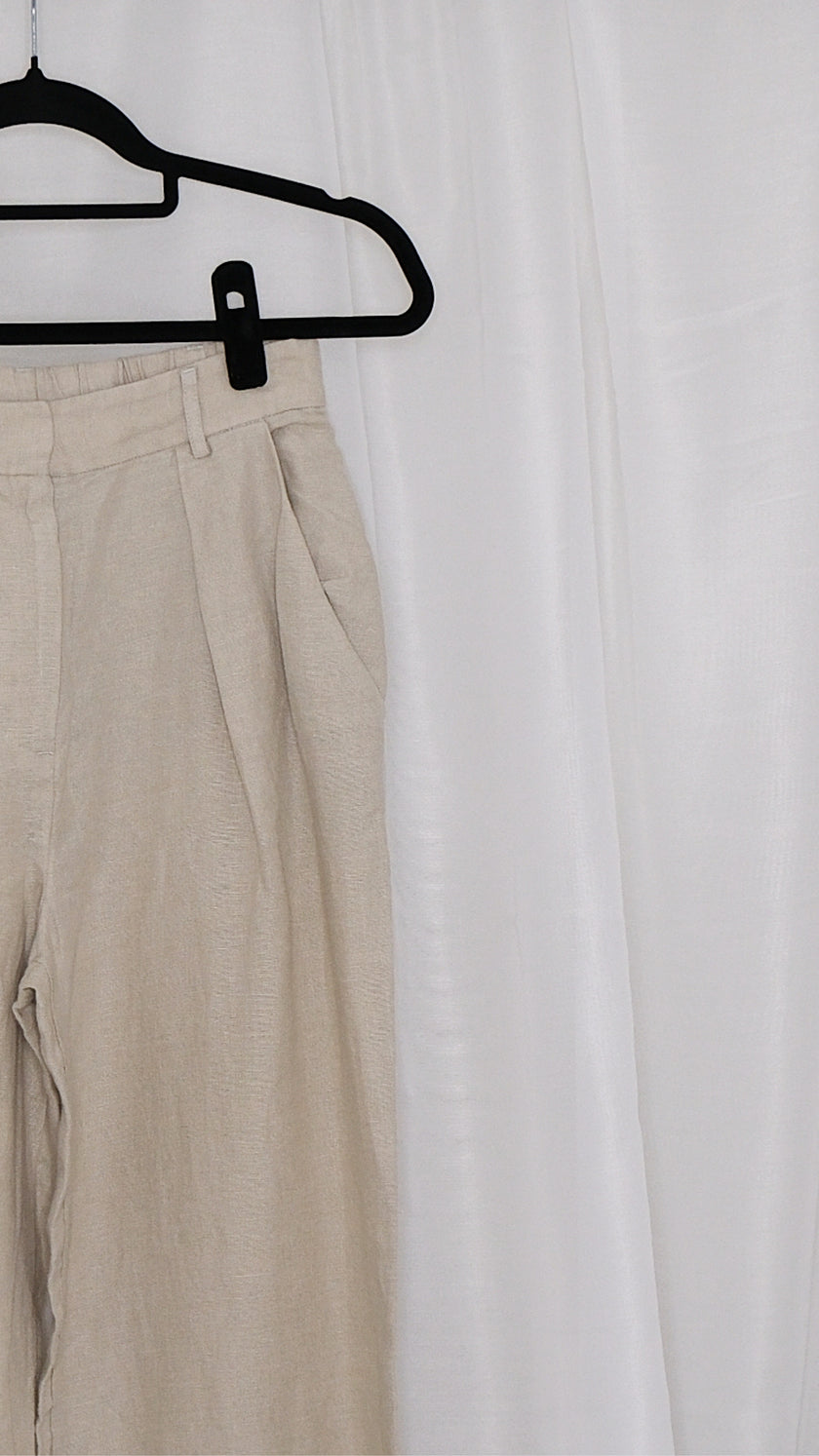 Beige pants on a hanger against a white background