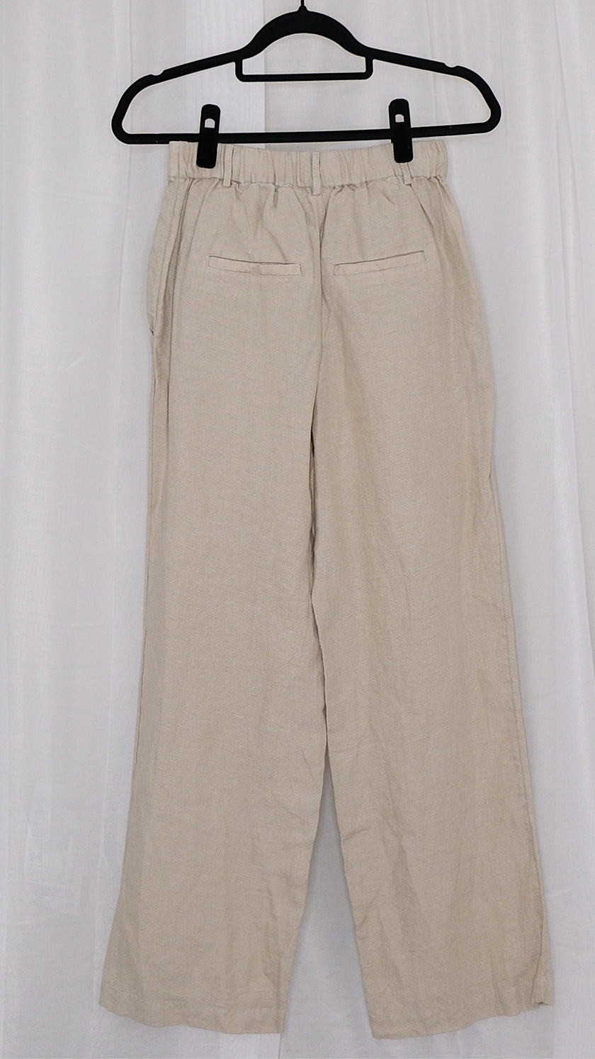 Beige pants on a hanger against a white background