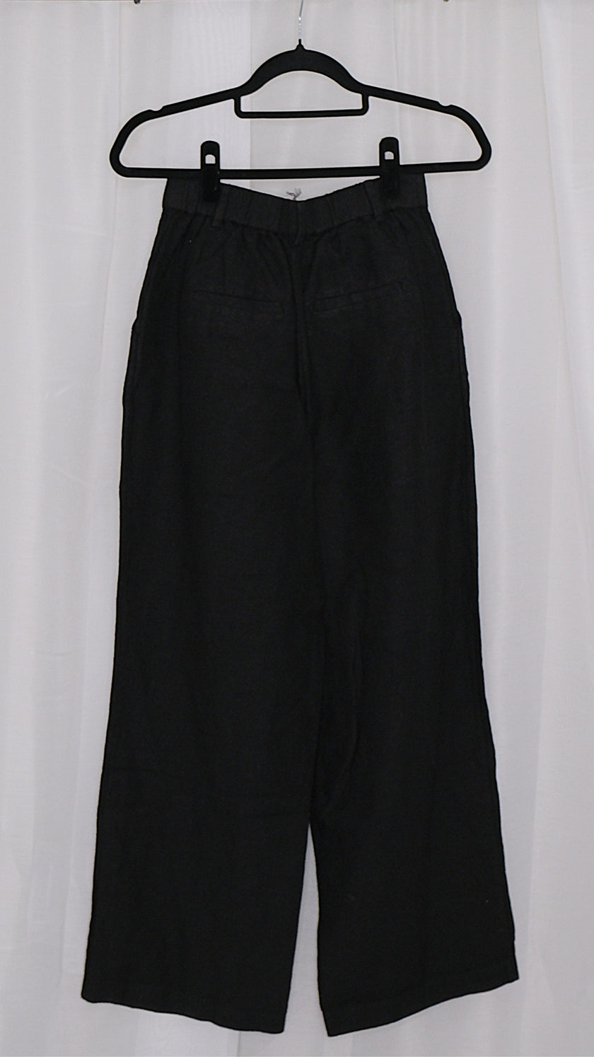 Black pants on a hanger against a white background
